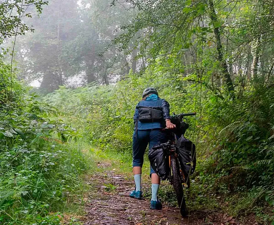 Ana Zamorano empujando su bici en uno de los bosques del norte de España.
